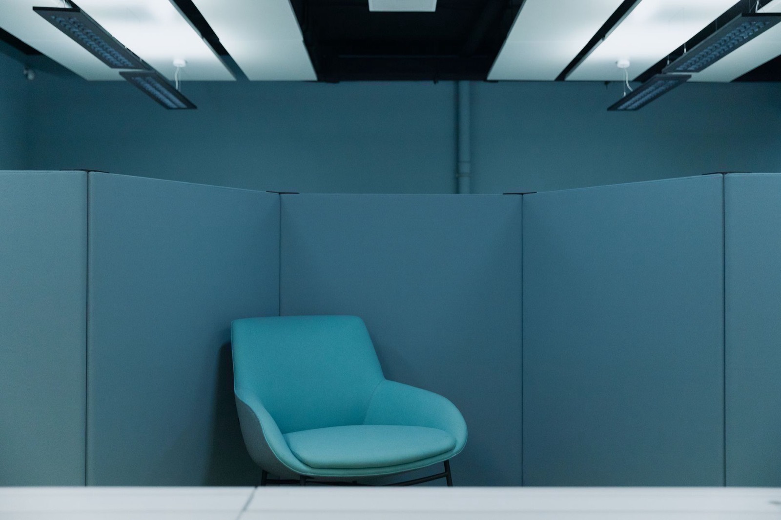 An empty office seating area with the lights on and nobody in it.