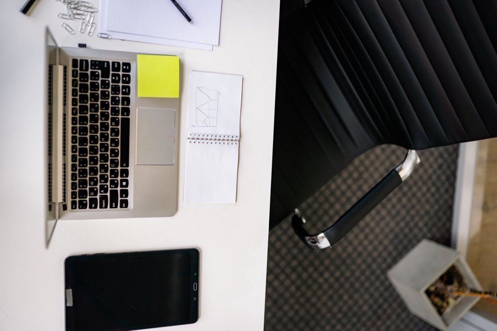 A founder filling in an online form, with a passport and notes on the desk beside the laptop.